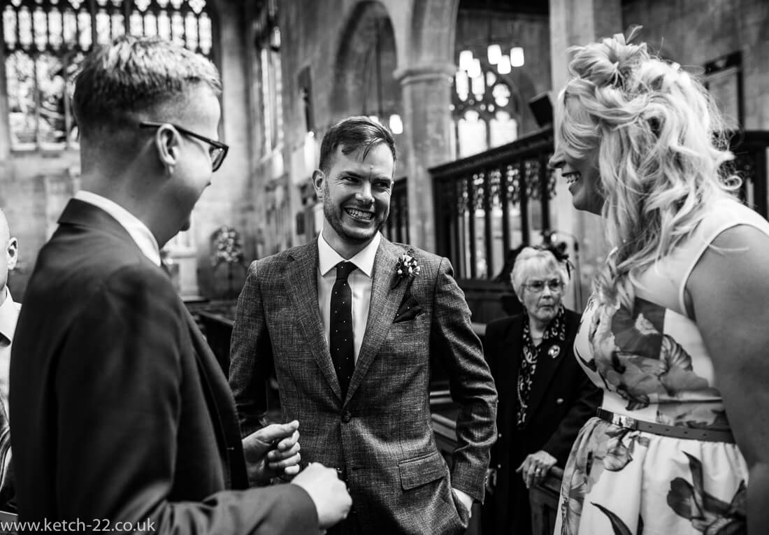 Groom laughing and greeting wedding guests