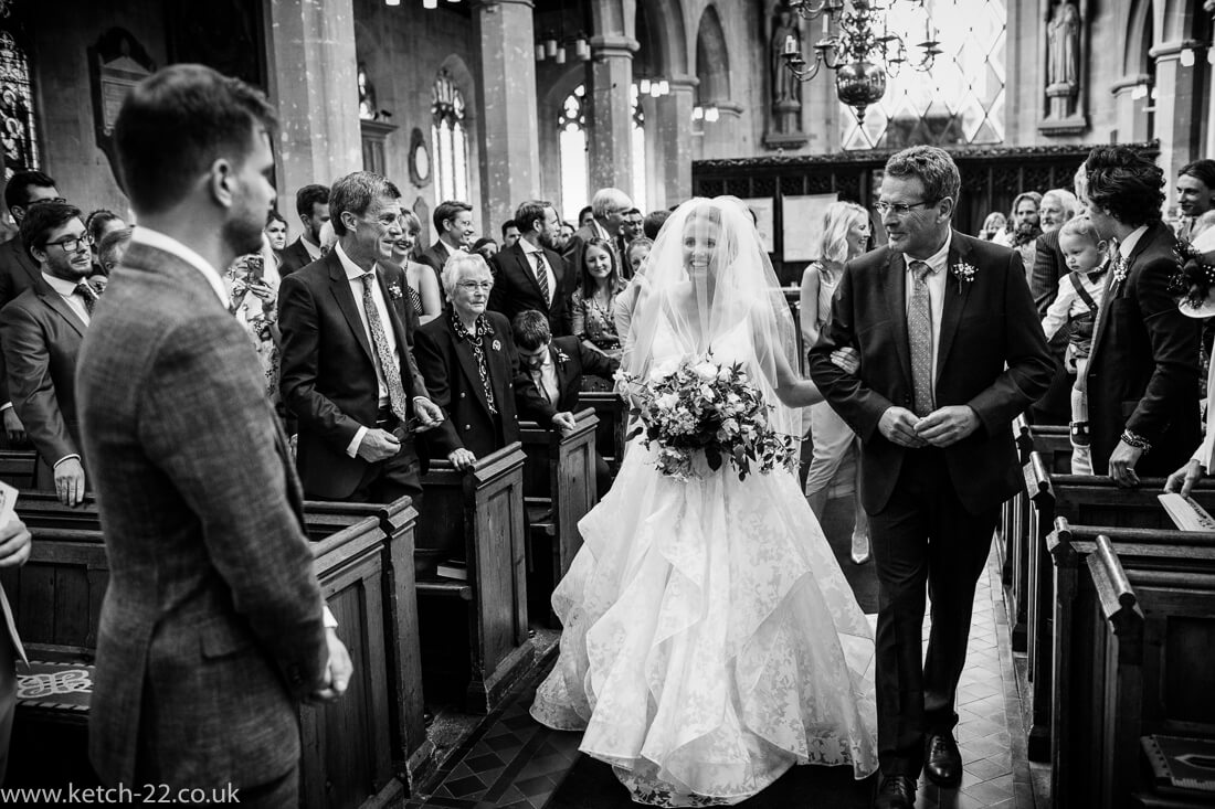 Bride looking at groom at she enters church wedding ceremony