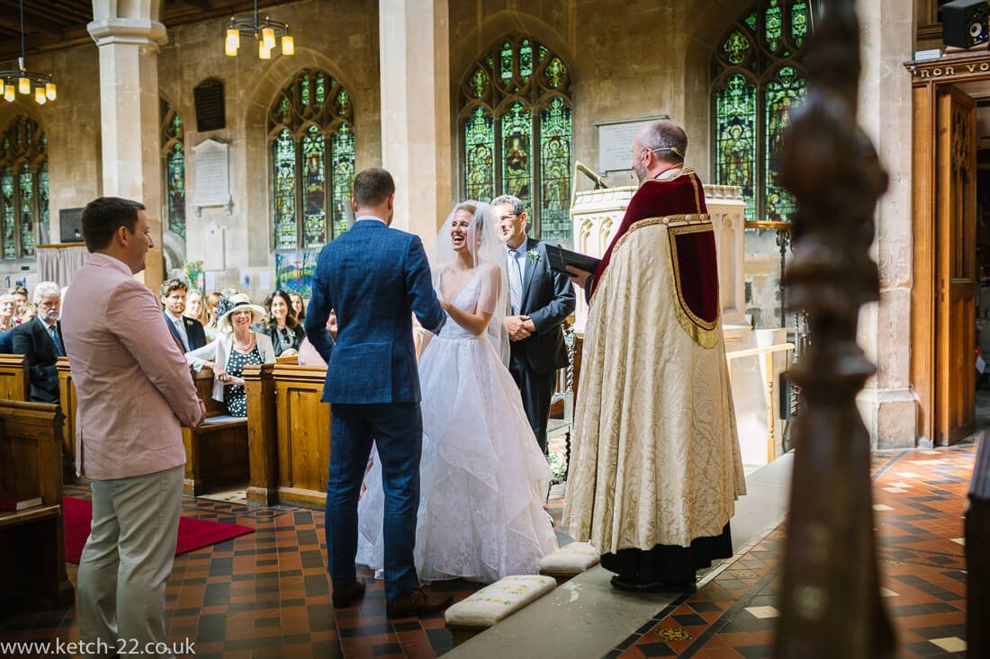 Reportage wedding photo of bride putting ring on groom