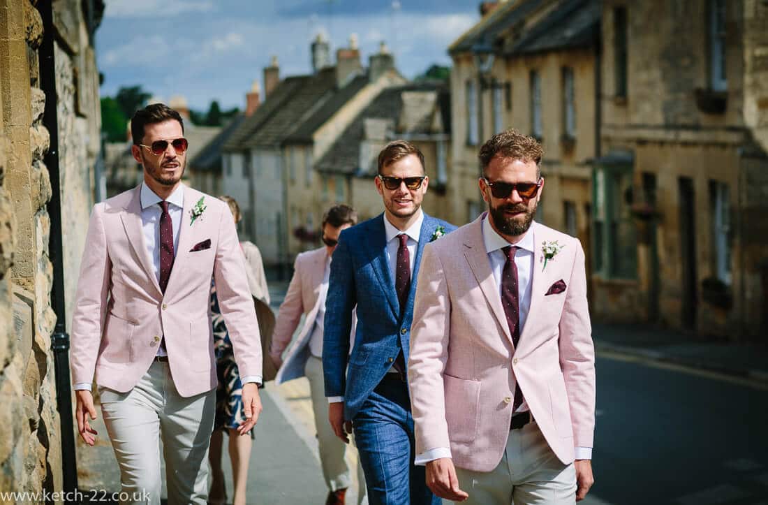 Groom in blue and best men in pink at wedding