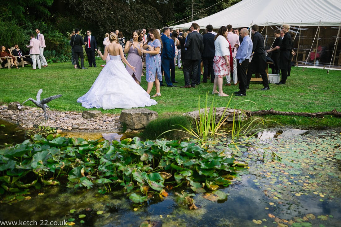 View of lilly pond and wedding guests in garden