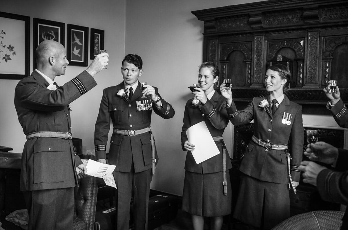 Groom in RAF uniform and friends tosting just prior to wedding