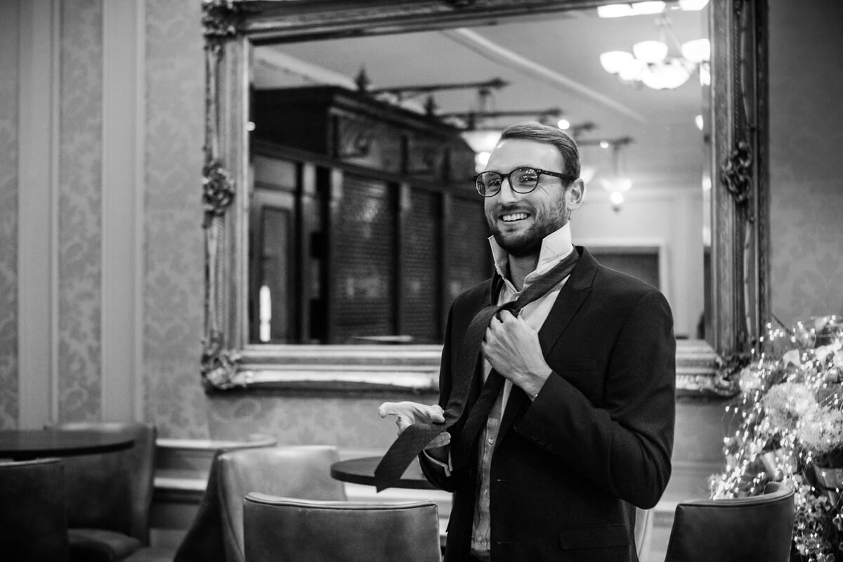 Wedding guest putting on tie