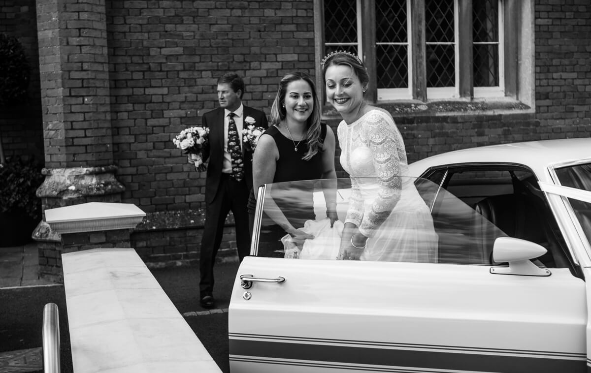 Bride getting out of wedding car