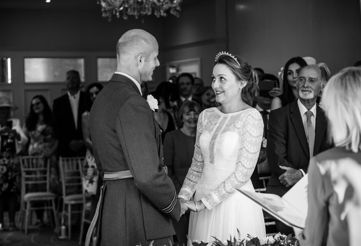 Bride and groom holding hands and looking at eachother