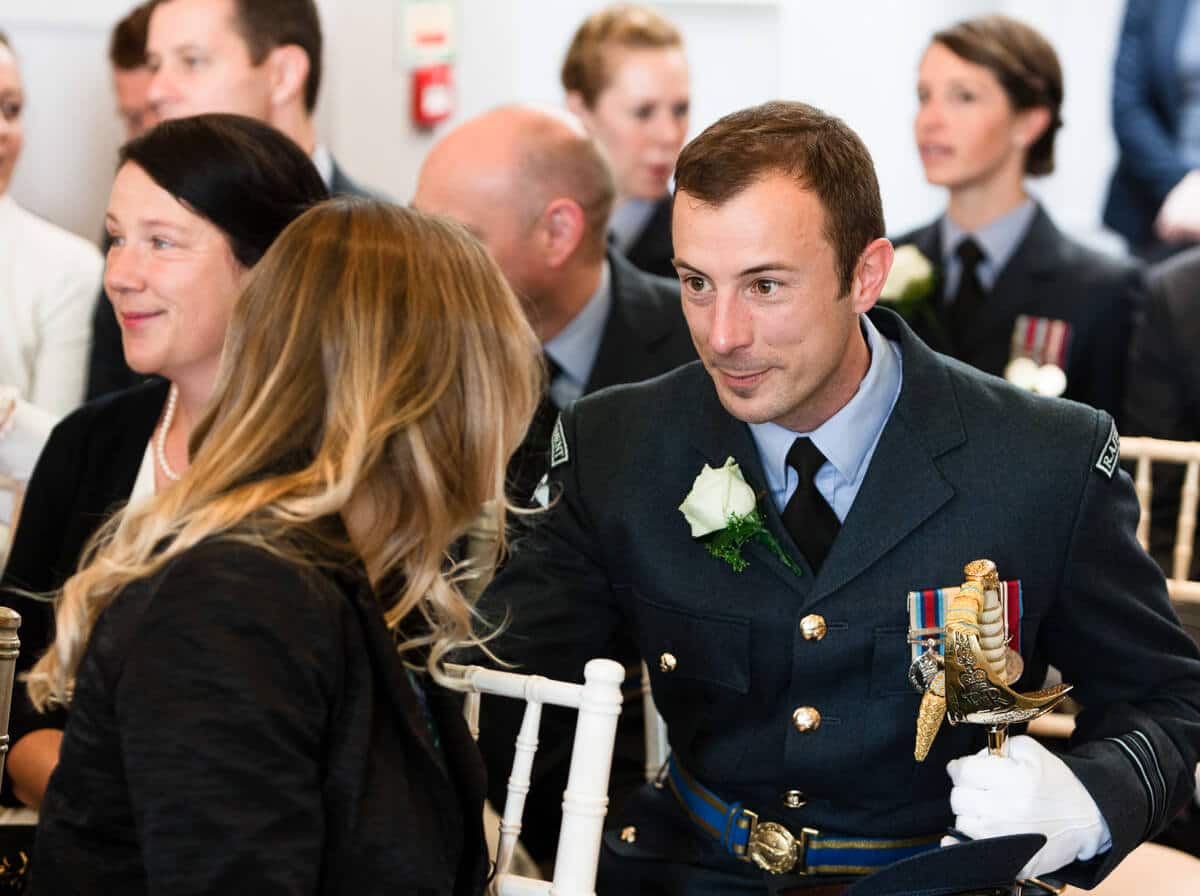 Wedding guest in RAF uniform chatting at wedding ceremony