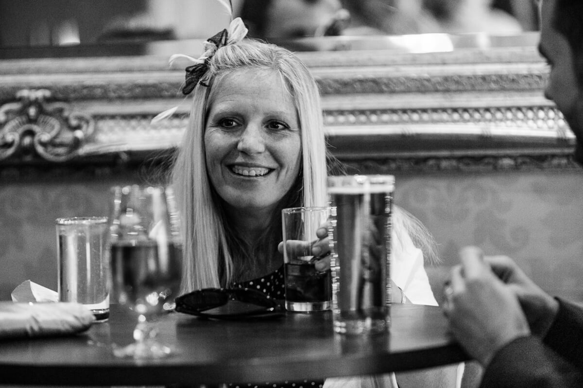 Black and white photo of wedding guest enjoying a drink