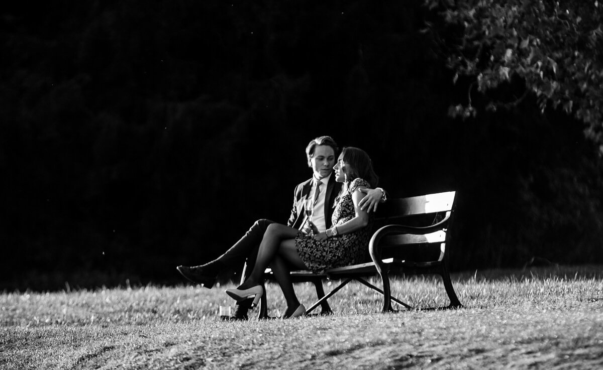 Romantic wedding guests sitting on bench