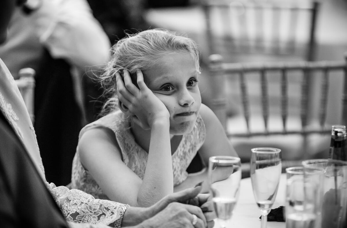 Bored looking little girl at wedding speeches