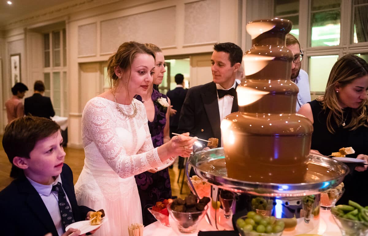 Bride enjoying chocolate fountain at wedding reception