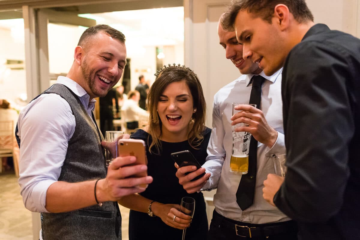 Wedding guest looking at phone and laughing