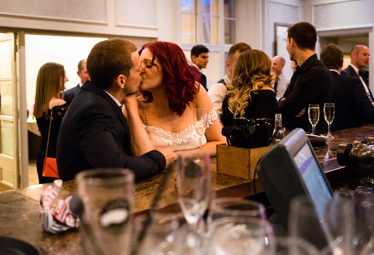 Wedding guests kissing at bar