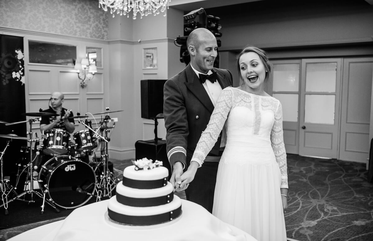 Bride and groom cutting wedding cake at country house wedding