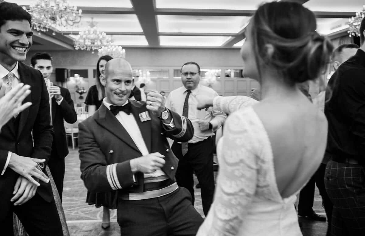 Groom in RAF uniform dancing with his bride at De Vere Latimer Estate wedding