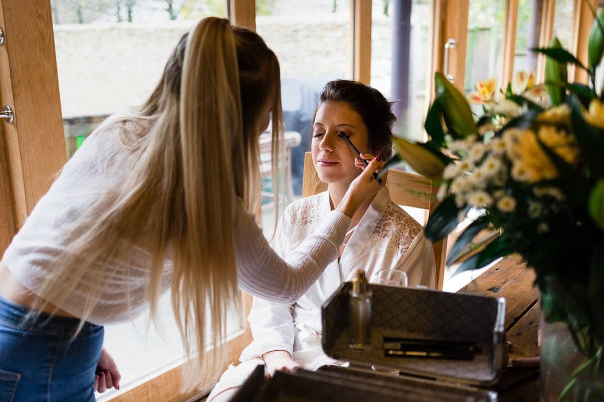 Bride having make up applied at Cripps Barn Wedding