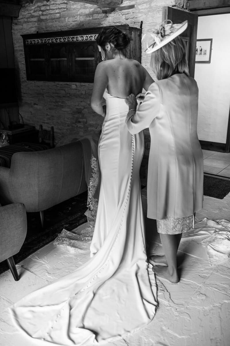 Mother buttoning up back of Wedding dress