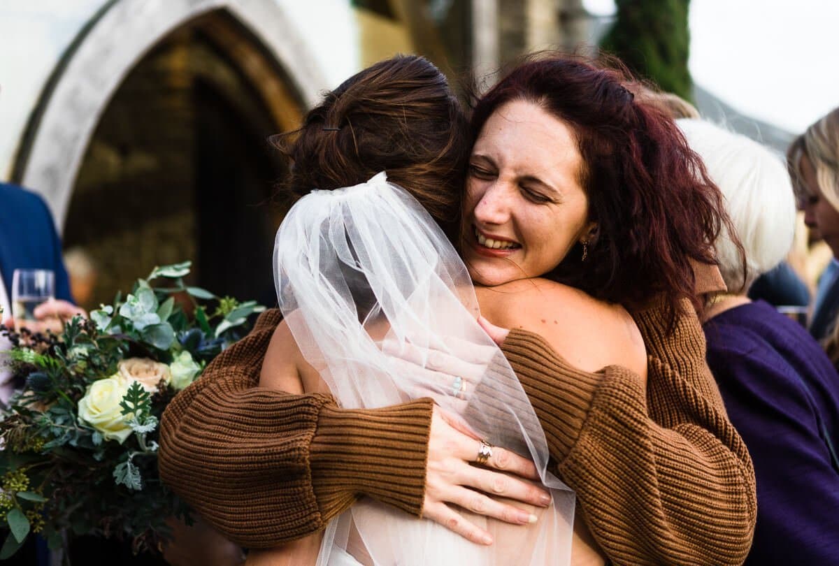 Emotional hug for bride by wedding guest