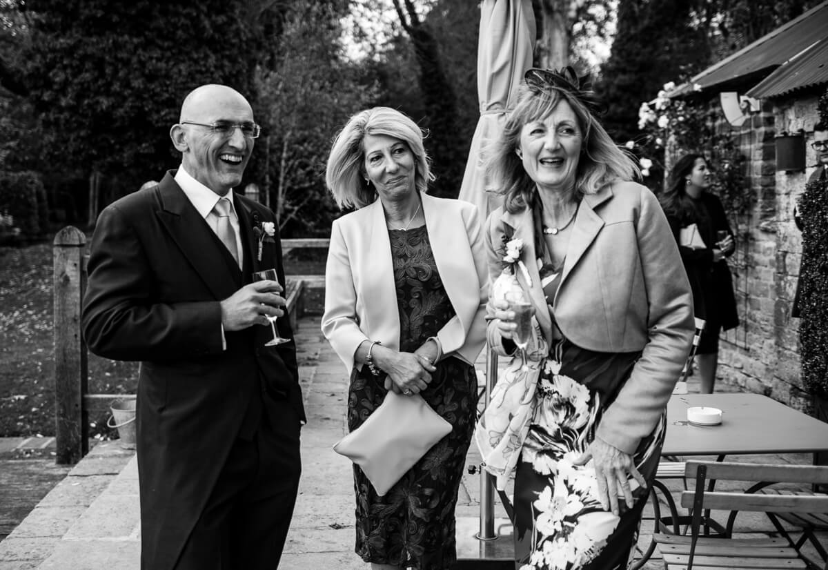 Family rtealxing with drinks and canapes after wedding