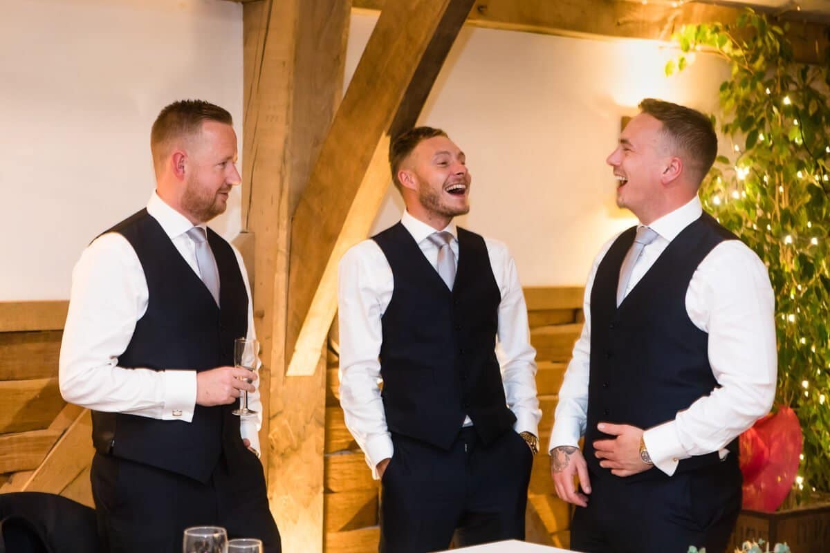 Groomsmen share a joke at wedding reception