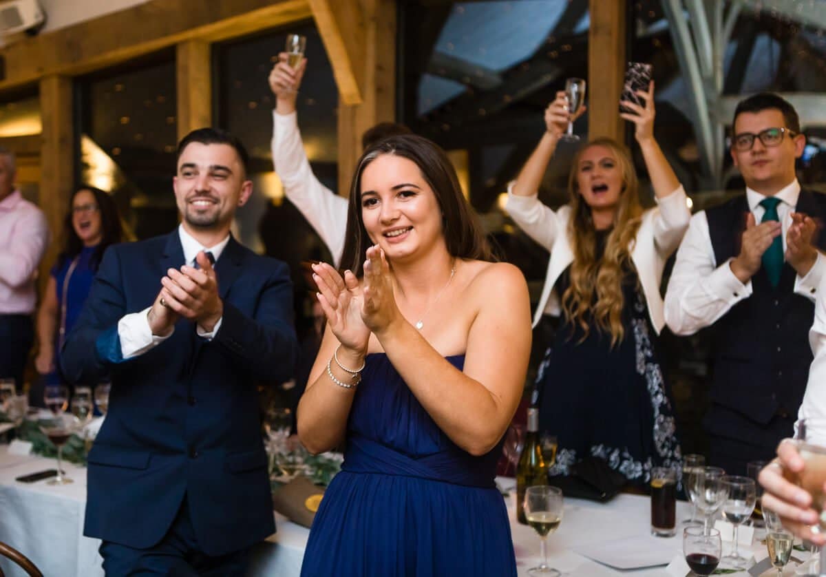 Wedding guests cheering and clapping at Cripps Barn