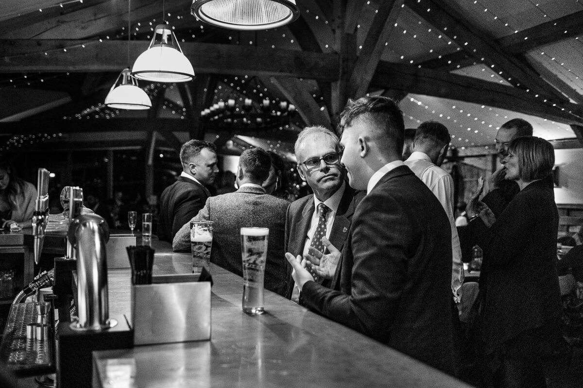 Wedding guests in conversation at bar