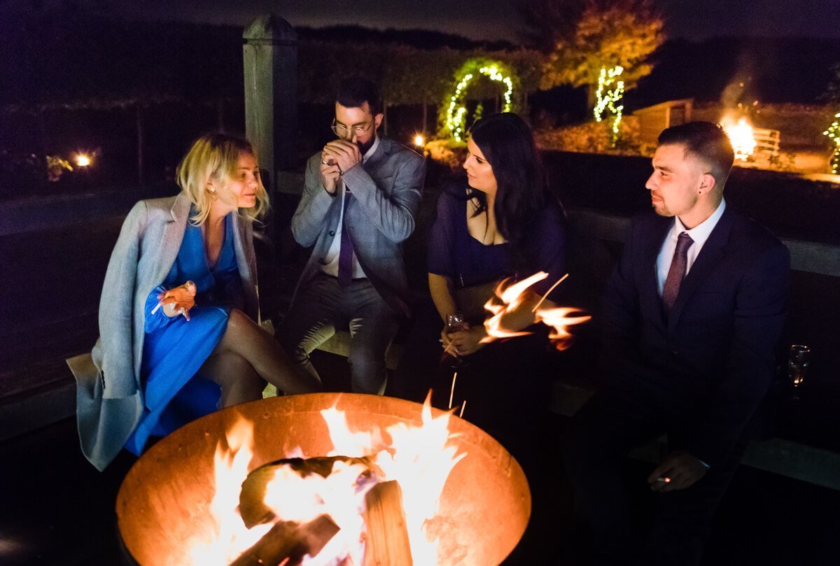 Guests enjoy outside fire at Cotswold Wedding, Cripps Barn